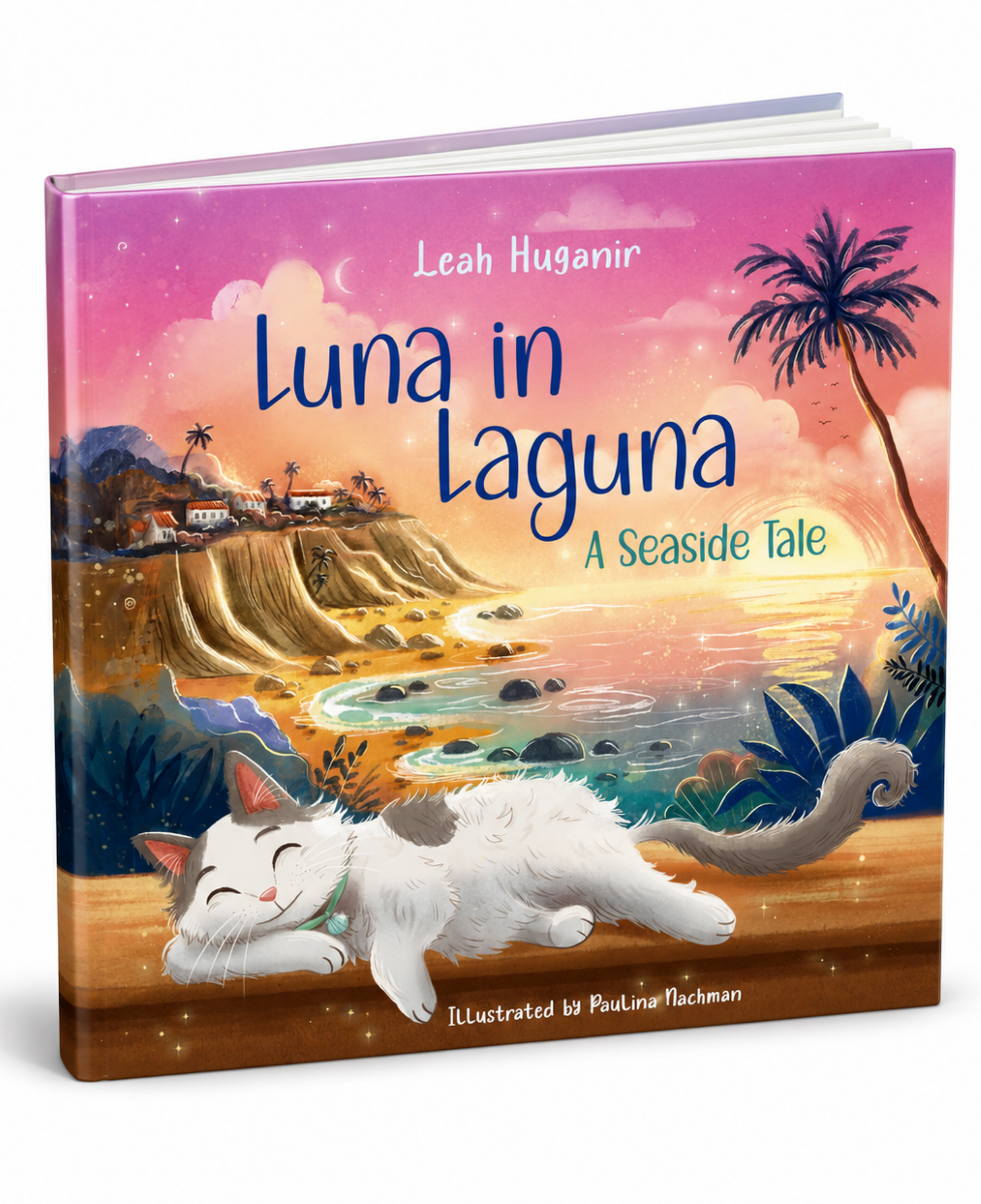 Children's book titled 'Luna in Laguna: A Seaside Tale' by Leah Huganir, illustrated by Paulina Flackman. The cover features a colorful sunset seascape with a white cat sleeping on a wooden ledge in the foreground.